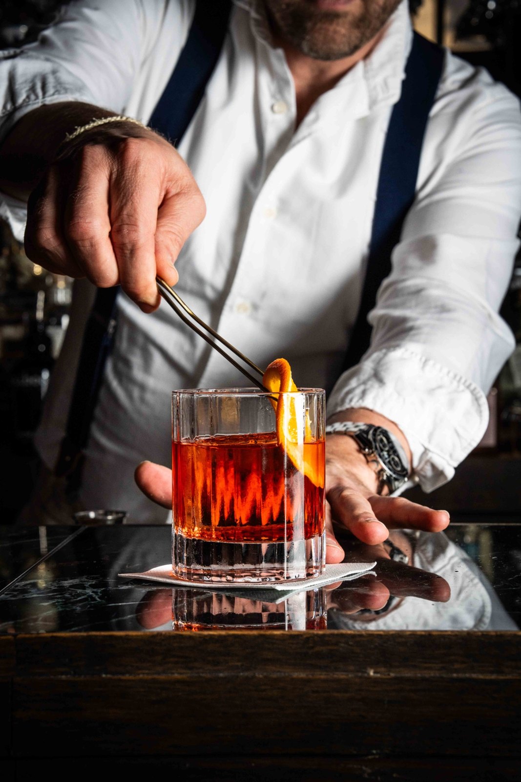 Social Roots photo of a bartender preparing a cocktail with orange
